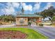 View of Summerglen community entrance with manicured landscaping and a decorative gatehouse beneath a bright blue sky at 15705 Sw 16Th Ter, Ocala, FL 34473