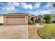 Charming single story home with tan exterior, attached garage, and beautiful landscaping at 15705 Sw 16Th Ter, Ocala, FL 34473