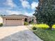 Charming single Gathering home boasts a two-car garage, manicured lawn, and a healthy shade tree on a sunny day at 15705 Sw 16Th Ter, Ocala, FL 34473