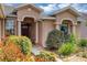 Inviting front entry with decorative columns and a beautiful landscape design, enhancing the home's curb appeal at 15705 Sw 16Th Ter, Ocala, FL 34473