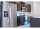 Close-up of stainless steel refrigerator and oven complimenting the dark cabinetry and white countertops at 15760 Sw 55Th Avenue Rd, Ocala, FL 34473