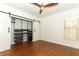 Bedroom with sliding barn door closet, hardwood floors, and ceiling fan at 2006 N Westmoreland Dr, Orlando, FL 32804