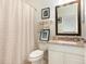 Cozy bathroom with white cabinets, granite countertop, decorative towels and matching shower curtain at 206 Norfolk Pl, Kissimmee, FL 34747