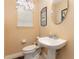 Powder room featuring a pedestal sink, decorative mirror, and neutral color scheme at 206 Norfolk Pl, Kissimmee, FL 34747