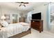 Cozy bedroom with a ceiling fan, natural light, dresser, and view of the ensuite bathroom at 206 Norfolk Pl, Kissimmee, FL 34747