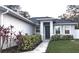 Inviting front entrance with a walkway, complemented by lush landscaping and a modern design at 207 Valencia Rd, Debary, FL 32713