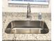 Close-up of stainless steel kitchen sink with granite countertop and modern chrome faucet at 207 Valencia Rd, Debary, FL 32713