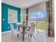 Cozy dining area with a round table, white chairs, and sliding glass doors leading to the backyard at 2116 Red Rock Rd, New Smyrna Beach, FL 32168