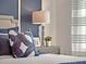 Bedroom detail showing end table, lamp and pillows with patterned decor at 2230 Lake Preserve Cir, New Smyrna Beach, FL 32168