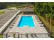 Overhead view of the community pool featuring ample lounge chairs, a covered pavilion, and verdant landscaping at 2230 Lake Preserve Cir, New Smyrna Beach, FL 32168