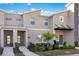 A contemporary townhome featuring a well-maintained exterior, green lawn, and modern architectural details at 2377 Reading Trl, Kissimmee, FL 34746