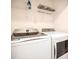 Convenient laundry room features a washer, dryer, ironing board, and storage at 2377 Reading Trl, Kissimmee, FL 34746