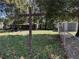 Wood cross structure on a sprawling backyard with mature trees, green grass, and a metal chain link fence at 2429 S Elm Ave, Sanford, FL 32771