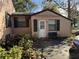 A cozy side entrance features dark shutters, a bench, and a small patio area at 2429 S Elm Ave, Sanford, FL 32771