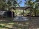 Open patio structure on a flat concrete slab, surrounded by greenery and storage units at 2429 S Elm Ave, Sanford, FL 32771