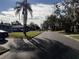 View of a street in a quiet neighborhood with palm trees, mature trees, and well-kept lawns at 2429 S Elm Ave, Sanford, FL 32771