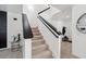 An interior shot of a stairway with black handrails and white walls and a decorative table and mirror at 3422 Seneca Club Loop # 57, Orlando, FL 32808