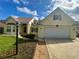 Inviting home with a two-car garage, well-maintained lawn, and a brick walkway leading to the front door at 413 Country Wood Cir, Lake Mary, FL 32746