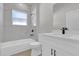 Bright bathroom with marbled tile shower, white cabinets, black hardware, and sink at 420 Marion Oaks Crse, Ocala, FL 34473