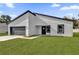 Angle view of modern house featuring a gray garage door and minimalist design at 420 Marion Oaks Crse, Ocala, FL 34473