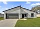 Modern home featuring a gray garage door, manicured lawn, and contemporary design at 420 Marion Oaks Crse, Ocala, FL 34473