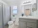 Bright bathroom with gray vanity, white countertops, and a gray shower curtain at 4371 Weeping Willow Cir, Casselberry, FL 32707