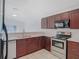 Well-lit kitchen featuring stainless steel appliances, quartz countertops, and rich wood cabinetry at 4371 Weeping Willow Cir, Casselberry, FL 32707