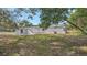 Exterior view of a white home featuring well-maintained lawn and mature trees at 5108 Balboa Dr, Orlando, FL 32808