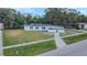 Aerial view of a charming white home with a dark roof, situated on a well-maintained lawn and a sidewalk at 5108 Balboa Dr, Orlando, FL 32808