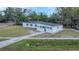 Aerial view of a charming white home with a dark roof, nestled in a lush, green landscape at 5108 Balboa Dr, Orlando, FL 32808