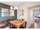 Dining area with a wood table, black chairs, mirrors, and a view leading to a bedroom at 5120 Conroy Rd # 32, Orlando, FL 32811