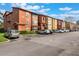 Exterior shot of a multi-story condo building featuring vibrant, warm colors and ample parking at 5120 Conroy Rd # 32, Orlando, FL 32811