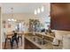 An open kitchen featuring granite countertops, dark cabinets, and lighting fixture. The kitchen flows into the living room at 5120 Conroy Rd # 32, Orlando, FL 32811