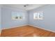 A light blue bedroom with two shuttered windows and hardwood floors at 625 Brechin Dr, Winter Park, FL 32792