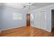 A light blue bedroom featuring hardwood floors, shuttered windows, and a ceiling fan at 625 Brechin Dr, Winter Park, FL 32792