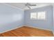 A light blue bedroom featuring hardwood floors, shuttered windows, and a ceiling fan at 625 Brechin Dr, Winter Park, FL 32792