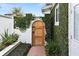 Charming wooden entry gate with lush ivy-covered walls and brick pathway creates a private garden entrance at 625 Brechin Dr, Winter Park, FL 32792