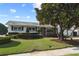 Well-manicured front yard of a charming single-story home featuring lush lawn, mature trees, and sculpted hedges at 625 Brechin Dr, Winter Park, FL 32792