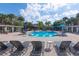 Spacious community pool with a wide sun deck, surrounded by lush landscaping and tall palm trees at 6542 Swissco Dr # 813, Orlando, FL 32822