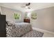 Cozy bedroom featuring marble floors, ceiling fan, and natural light from two windows at 705 Liberty St, Eustis, FL 32726