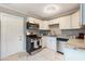 Well-lit kitchen featuring stainless steel appliances, white cabinets, and modern finishes at 705 Liberty St, Eustis, FL 32726