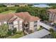 Aerial view of multi-Gathering building with covered parking, mature trees, and manicured landscaping at 7123 Yacht Basin Ave # 328, Orlando, FL 32835