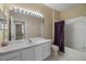 Bathroom features dual sinks, large mirror, and tub with shower at 7123 Yacht Basin Ave # 328, Orlando, FL 32835