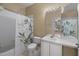 Bright bathroom features a vanity with ample storage and a shower-tub combination with decorative curtain at 7123 Yacht Basin Ave # 328, Orlando, FL 32835