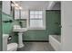 Retro bathroom showcasing green tile, a pedestal sink, and classic fixtures at 728 N Summerlin Ave, Orlando, FL 32803