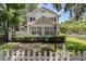 Well-manicured lawn with a picket fence and mature trees surrounding this two-story home at 728 N Summerlin Ave, Orlando, FL 32803