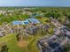 An aerial view of the community pool, clubhouse, golf course, and parking lot at 7296 Sw 115Th Pl, Ocala, FL 34476