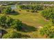 Picturesque aerial view capturing a lush green golf course, pond, and trees at 7296 Sw 115Th Pl, Ocala, FL 34476