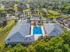 Aerial view of the community pool surrounded by buildings, parking, and a lush golf course at 7296 Sw 115Th Pl, Ocala, FL 34476