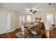 Dining room with a wooden table, striped chairs, a ceiling fan, and views of the kitchen and bathroom at 7296 Sw 115Th Pl, Ocala, FL 34476